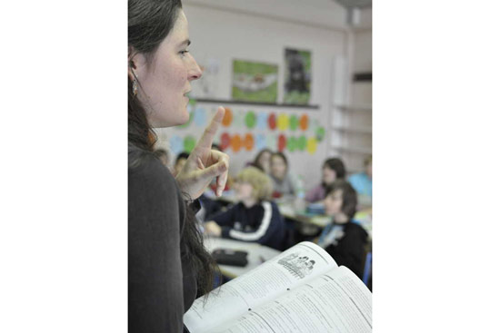 Lehrerin die aus einem Buch unterrichet