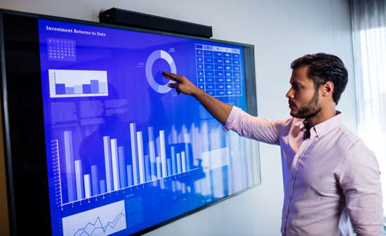 Geschäftsmann analysiert Daten auf einem großen Touchscreen
