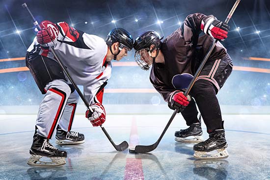 Zwei Eishockey-Spieler balgen in einer Eisarena um den Puck