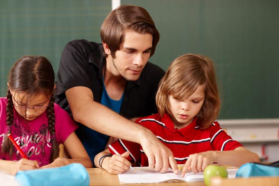 Grundschullehrer erklärt einer Schülerin etwas