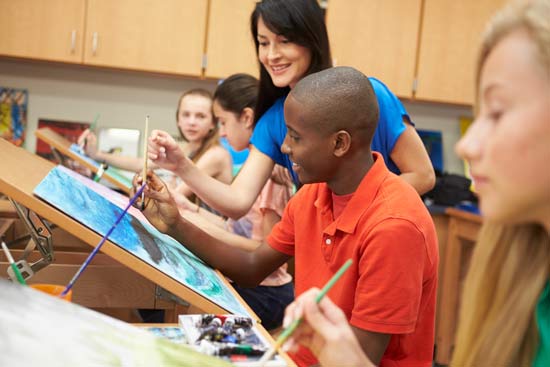 Kunstlehrerin mit malenden Schüler:innen