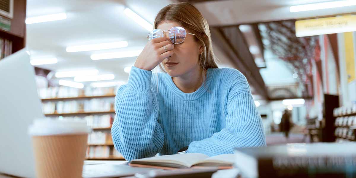 Studentin in der Bibliothek wirkt gestresst