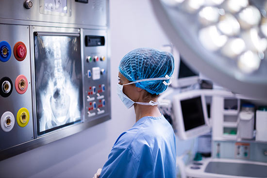 Ärztin steht vor einem belichteten Röntgenbild