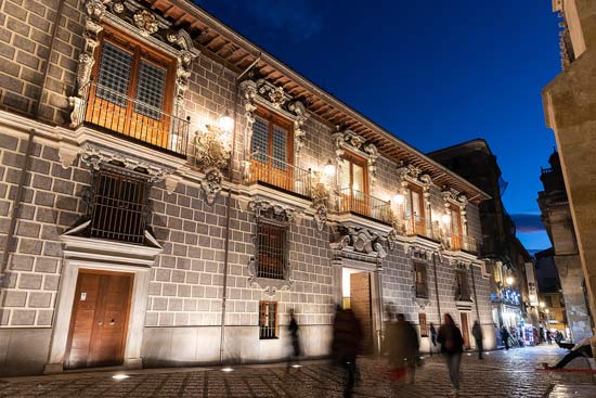 Altstadt von Grenada (Spanien) in der Nacht; im Hintergrund beleuchtet das historische Gebäude Madraza de Granada