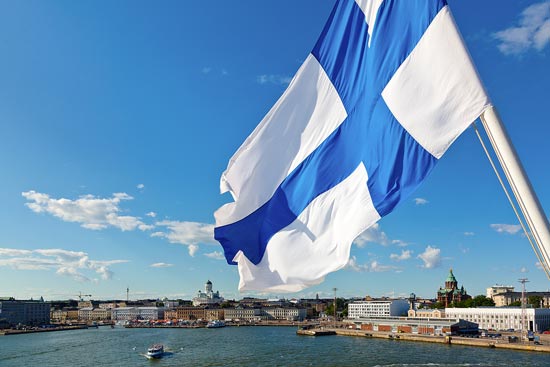 Blick von einem Schiff auf Helsinki – mit einer finnischen Fahne im Wind
