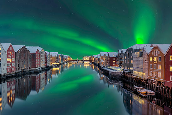 Lagerhäuser im norwegischen Trondheim umgeben von Nordlichtern