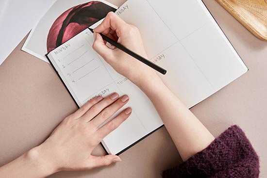 Studentin schreibt in ihr Bullet Journal