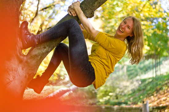 Junge Frau klettert auf einem Baum herum