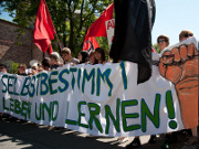 Demonstranten halten gemeinsam Banner mit der Aufschrift